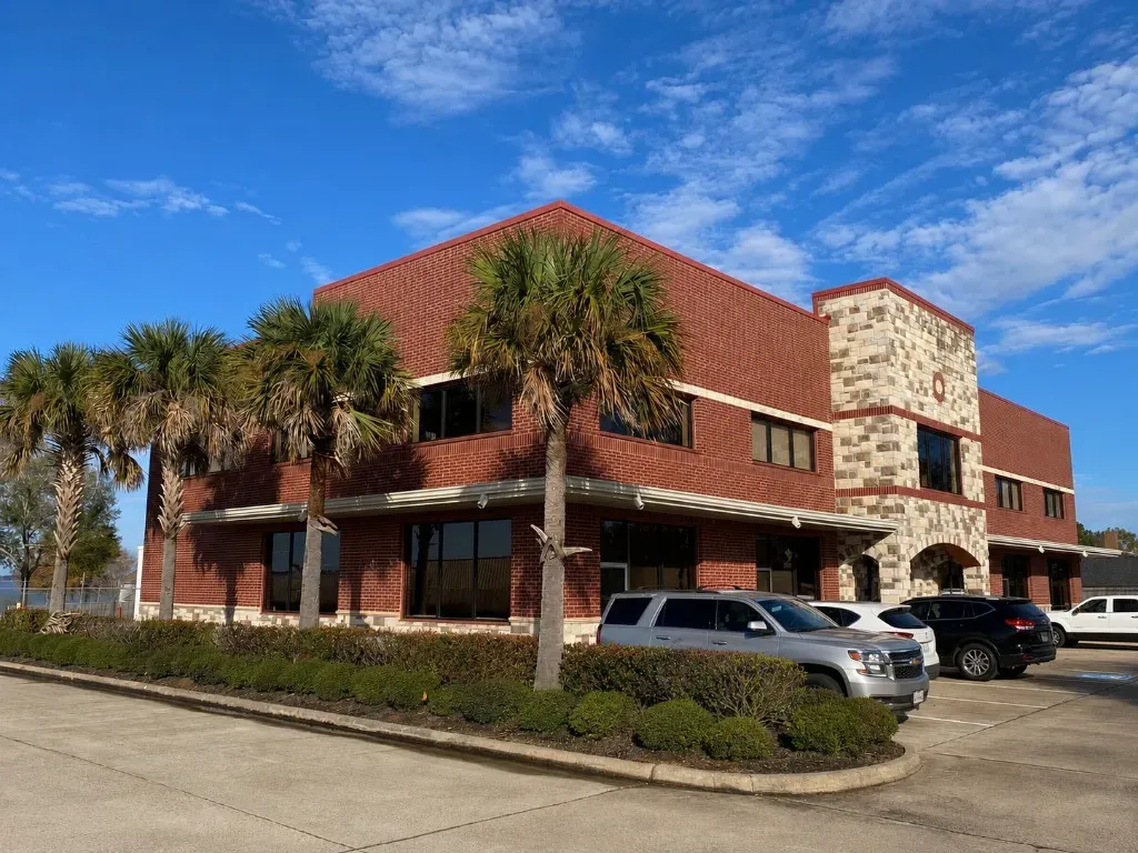 Beach Walk Office Suites exterior in Conroe near Lake Conroe, with brick facade and palm trees