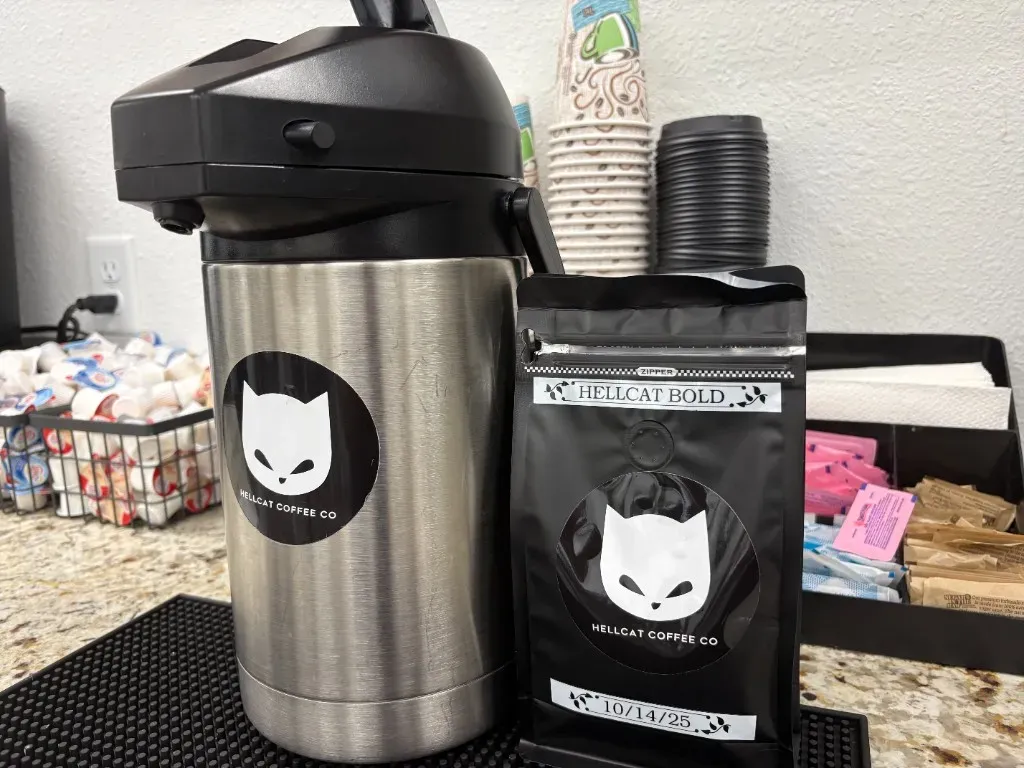 Hellcat Coffee airpot and locally roasted coffee bag at the complimentary coffee station